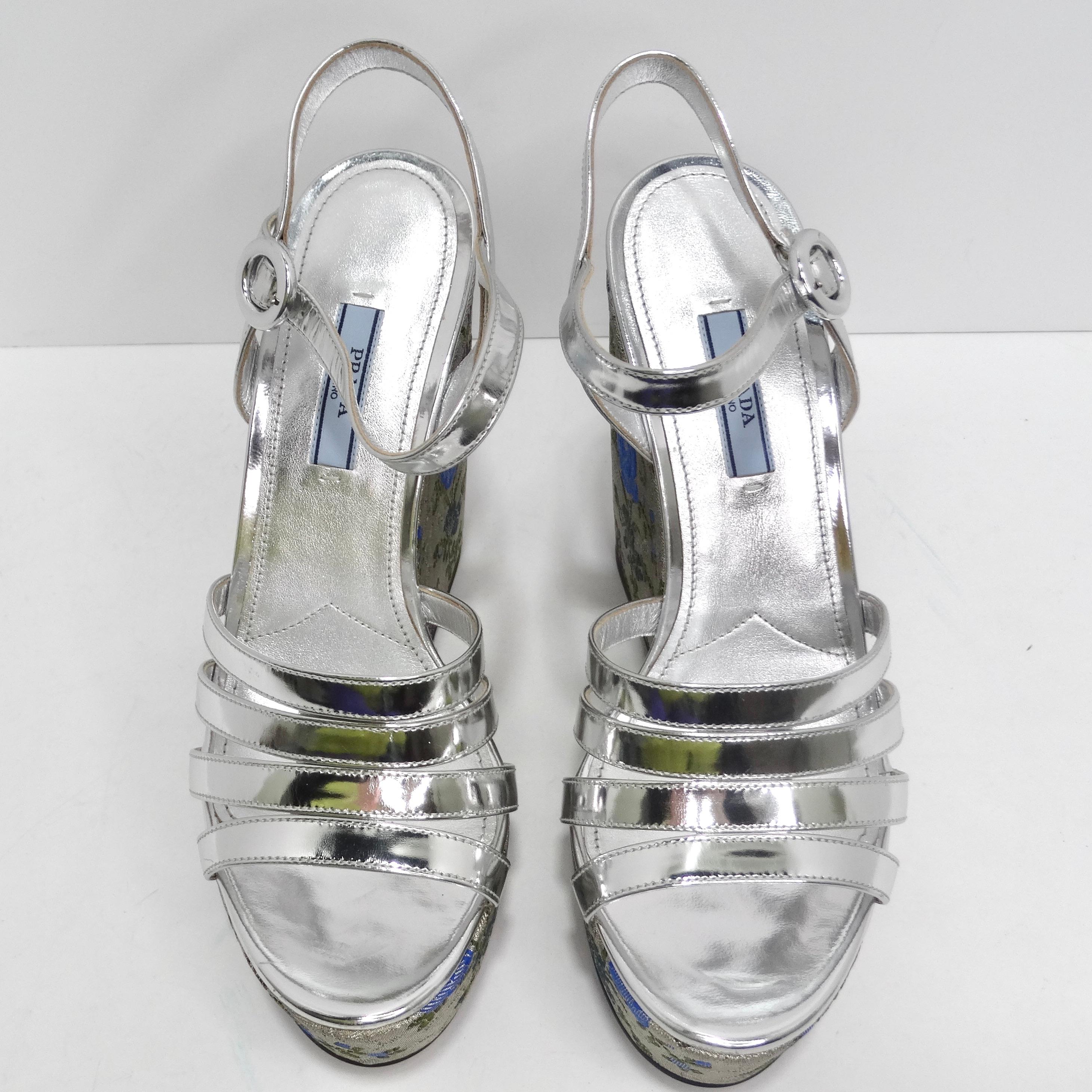 Introducing a pair of shoes that combine elegance with a touch of whimsy - the Prada Metallic Silver Floral Jacquard Leather Wedge Sandals. These metallic silver leather heels with a vibrant floral print wedge and strappy design are more than just