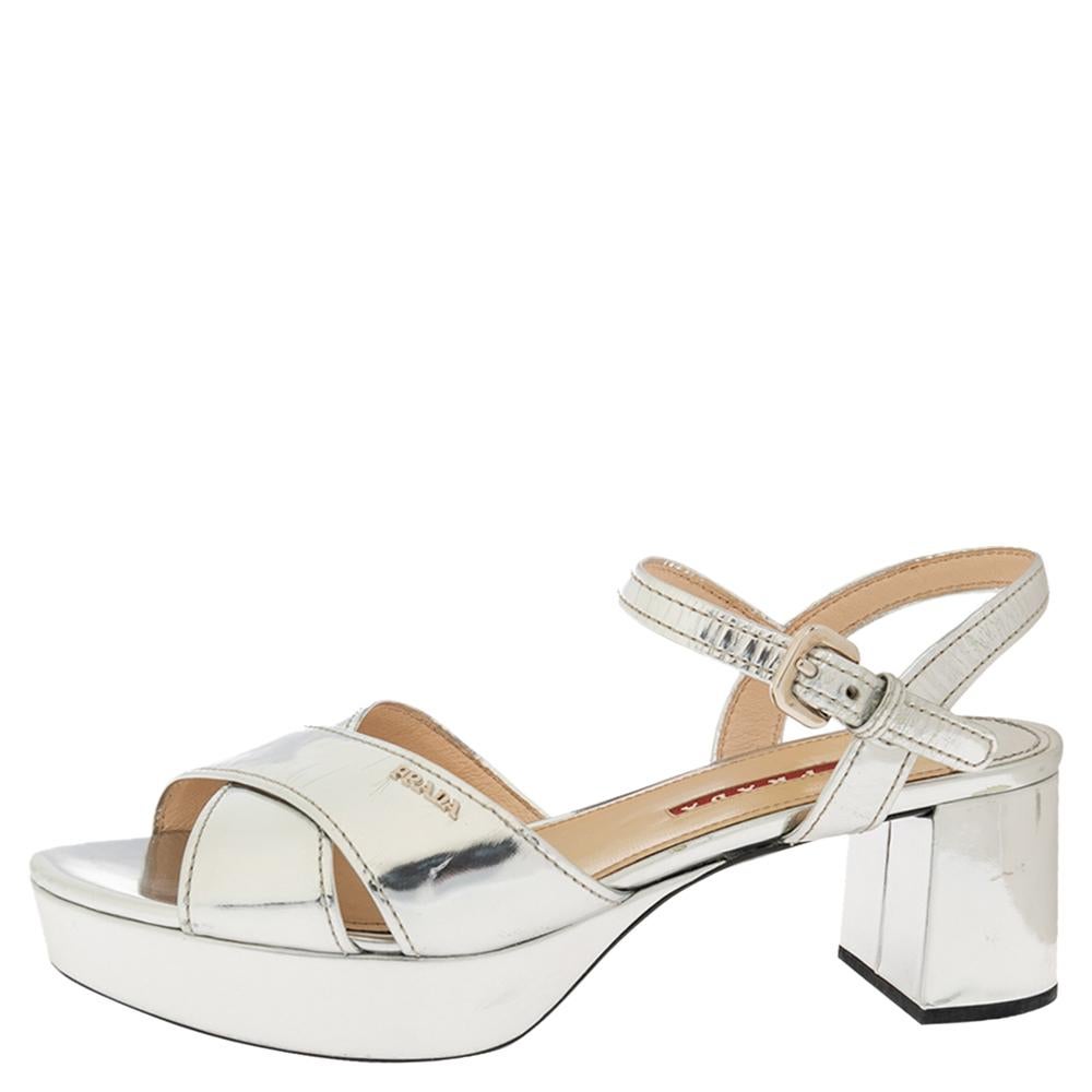 Giving out a luminous glow, this pair of sandals from the house of Prada is a trendy addition to your style. Crafted from metallic silver leather, the sandals can be sported with your evening ensembles for maximum impact. Block heels and platforms