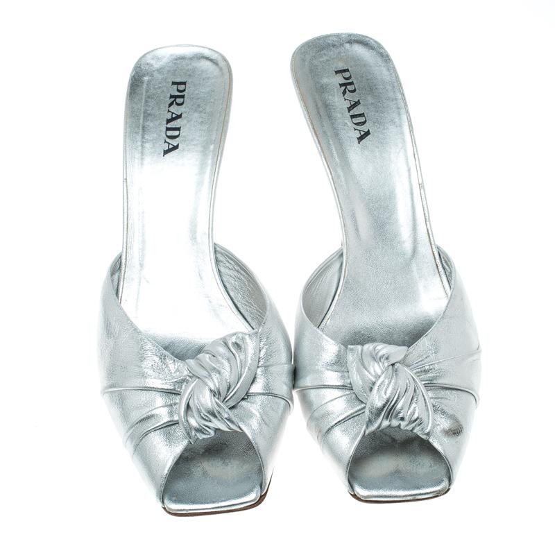 Scintillating and shimmering like no other, these slide sandals from Prada will make you fall in love with them! These metallic silver sandals are crafted from leather and feature a square peep-toe silhouette. They flaunt a twisted knot detailing on