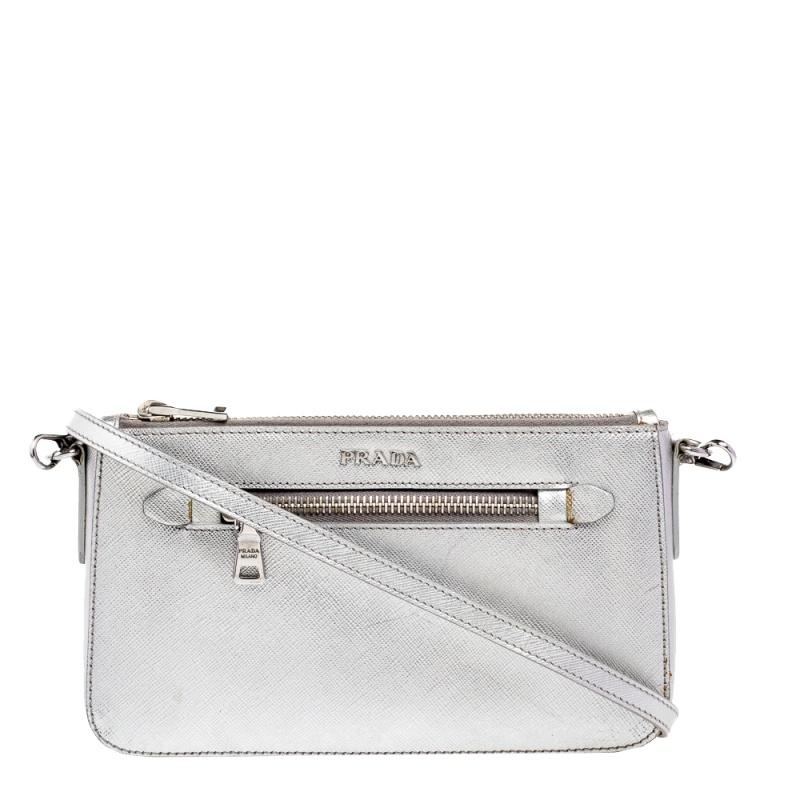 Incredibly stylish and statement-making, this crossbody bag from Prada is sure to be an amazing buy! The metallic silver creation is crafted from Saffiano leather and styled with a front pocket. It is held by a thin shoulder strap and opens to a