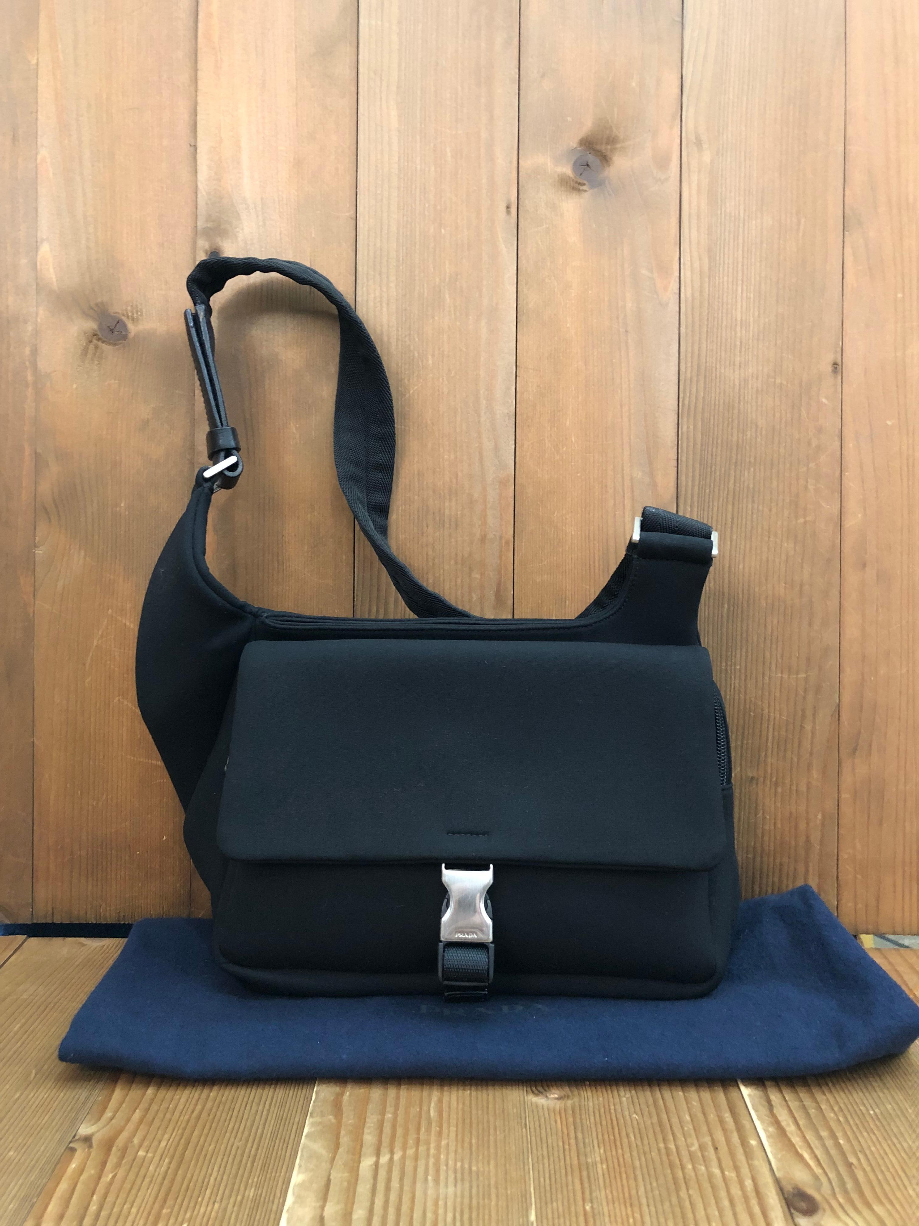 This PRADA crossbody sling bag is crafted of light-weight microfiber fabric in black featuring stainless steel hardware. Front flap buckle closure opens to a zippered pocket with Prada’s jacquard interior. This Prada bag also features back pocket