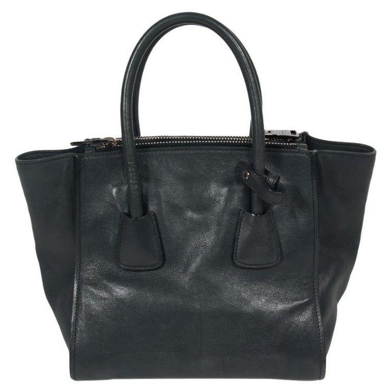 Prada’s Tote is smartly structured to lend a distinguished look. Crafted from calfskin leather, it features the triangular Prada’s logo on the front along with dual top rolled handles and a detachable shoulder strap. It comes with dual exterior