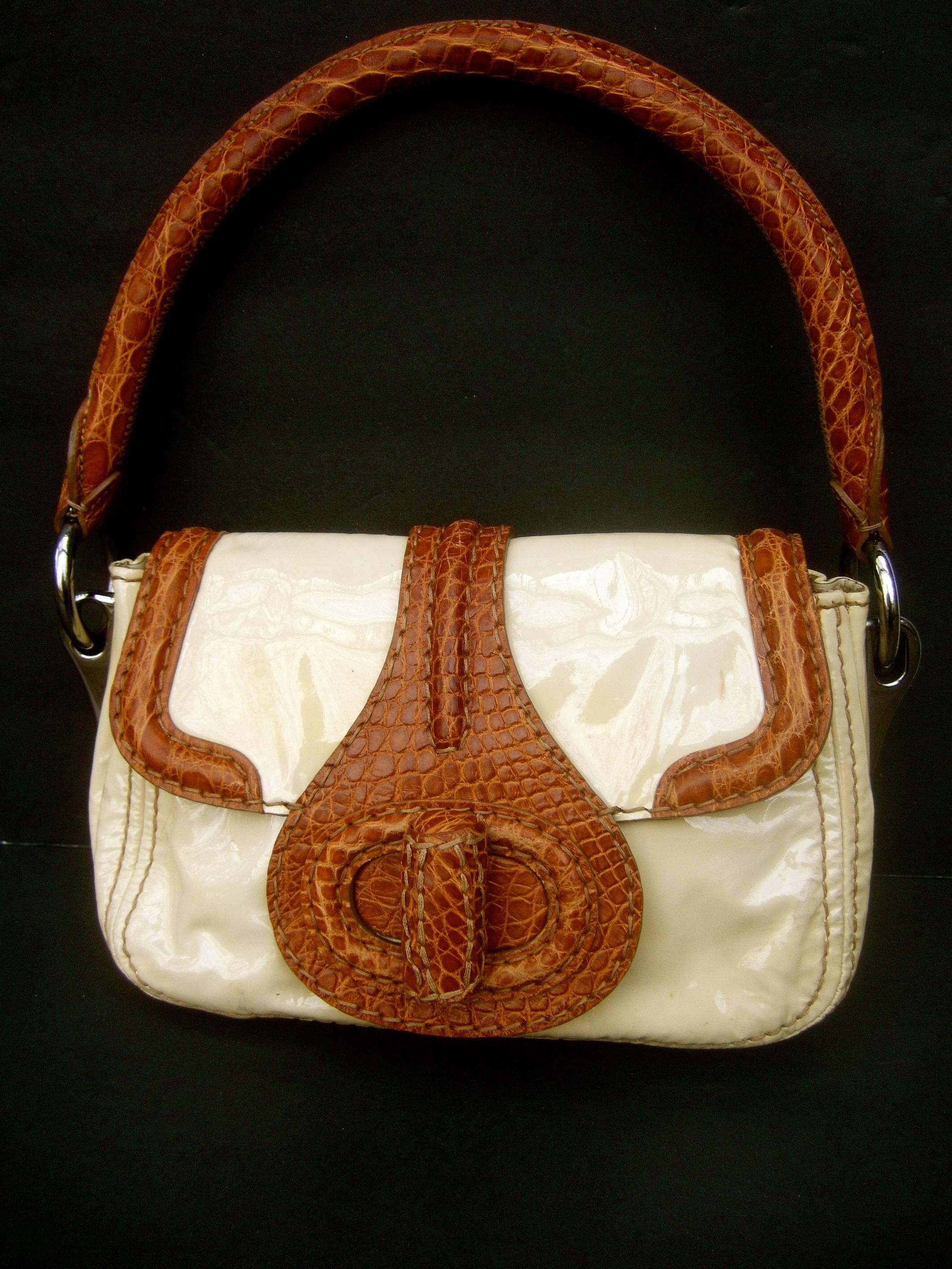 Prada Milano tan patent leather embossed trim handbag c 1990s
The stylish Italian handbag is covered with glossy tan
color patent leather 

The handle, flap cover trim and clasp are distinguished 
with brown embossed leather that emulates reptile