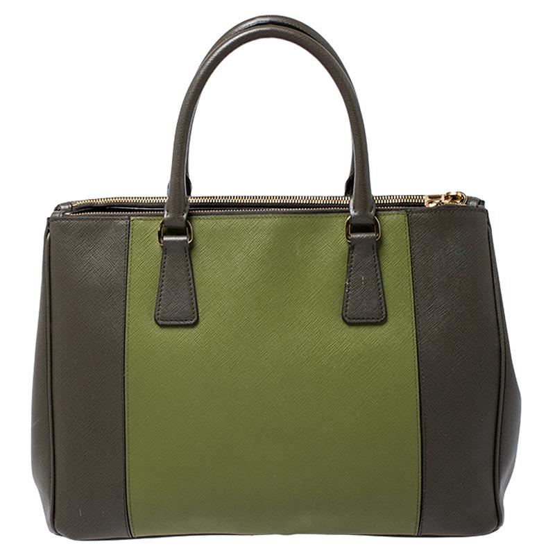 Feminine in shape and grand on design, this Double Zip tote by Prada will be a loved addition to your closet. It has been crafted from leather and styled minimally with gold-tone hardware. It comes with two top handles, two zip compartments and a