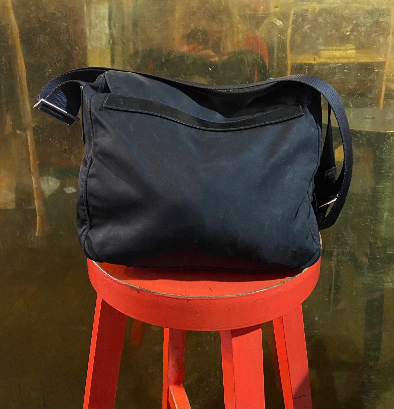 Vintage Mini Prada Crossbody Bag Features nylon outer layer. Black canvas handle, Zip on the top and front of the bag with pocket. Prada Logo in metal on front of bag. In excellent vintage condition. 

Brand: Prada
Color: Black
Fabric: