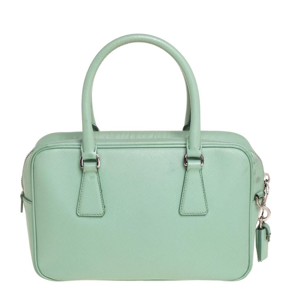 Packed with style and practical design sensibility, this bag by Prada is a handy fashion accessory. It is crafted using mint green leather and designed with a zip-enclosed interior, two handles, and a detachable shoulder strap. The triangular Prada