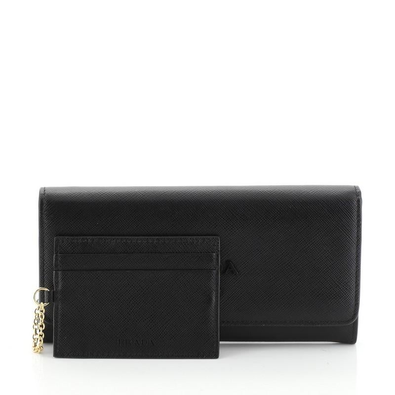 This Prada Monochrome Continental Wallet Saffiano Leather Long, crafted in black leather, features raised Prada logo and gold-tone hardware. Its snap button closure opens to a black leather interior with multiple card slots and zip pocket.