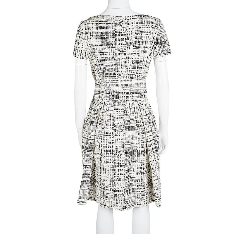 Dresses like this one from Prada are worthy of your closet-love as it carries a unique design and high style. Stunning in monochrome prints, the silk dress has short sleeves and pocket details. A pair of white sandals will complete this