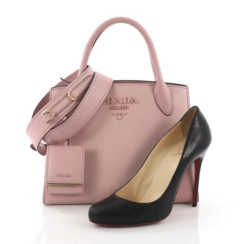 This Prada Monochrome Tote Saffiano Leather with City Calfskin Small, crafted in pink saffiano leather with city calfskin, features dual rolled leather handles, side snap buttons, and gold-tone hardware. It opens to a pink fabric interior with side