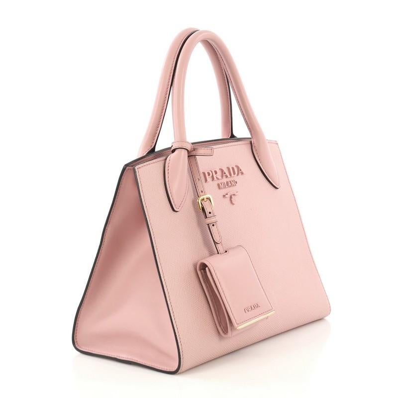 This Prada Monochrome Tote Saffiano Leather with City Calfskin Small, crafted from pink saffiano leather with city calfskin, features dual rolled leather handles, Prada logo on front, and gold-tone hardware. It opens to a pink leather and fabric
