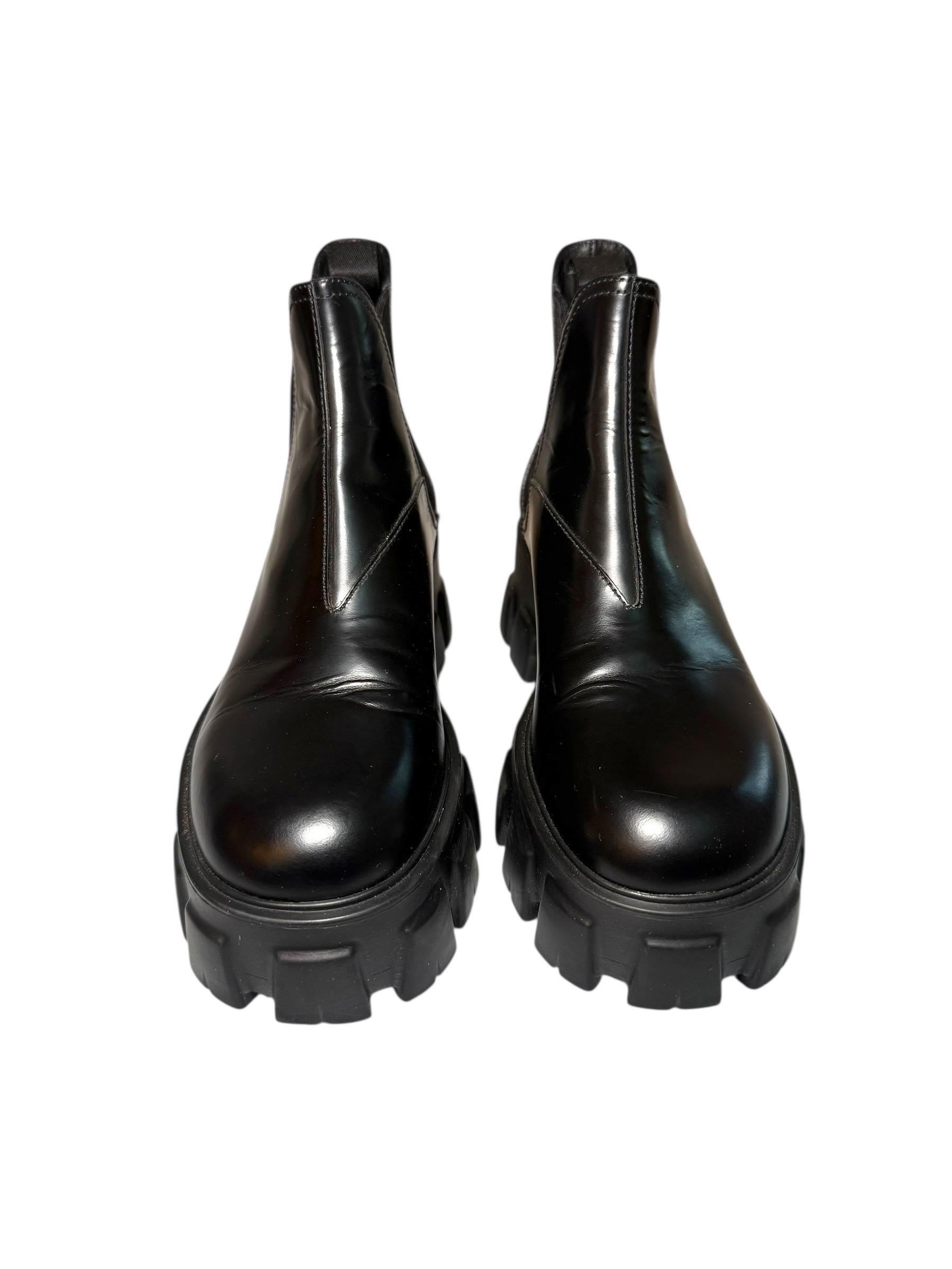 Prada - Monolith Lug-Sole Polished Leather Chelsea Boots - FW21 - Size 38

Élevez votre garde-robe avec les emblématiques bottes Chelsea Monolith de Prada, confectionnées en Italie en cuir lisse noir poli et montées sur la semelle à crampons