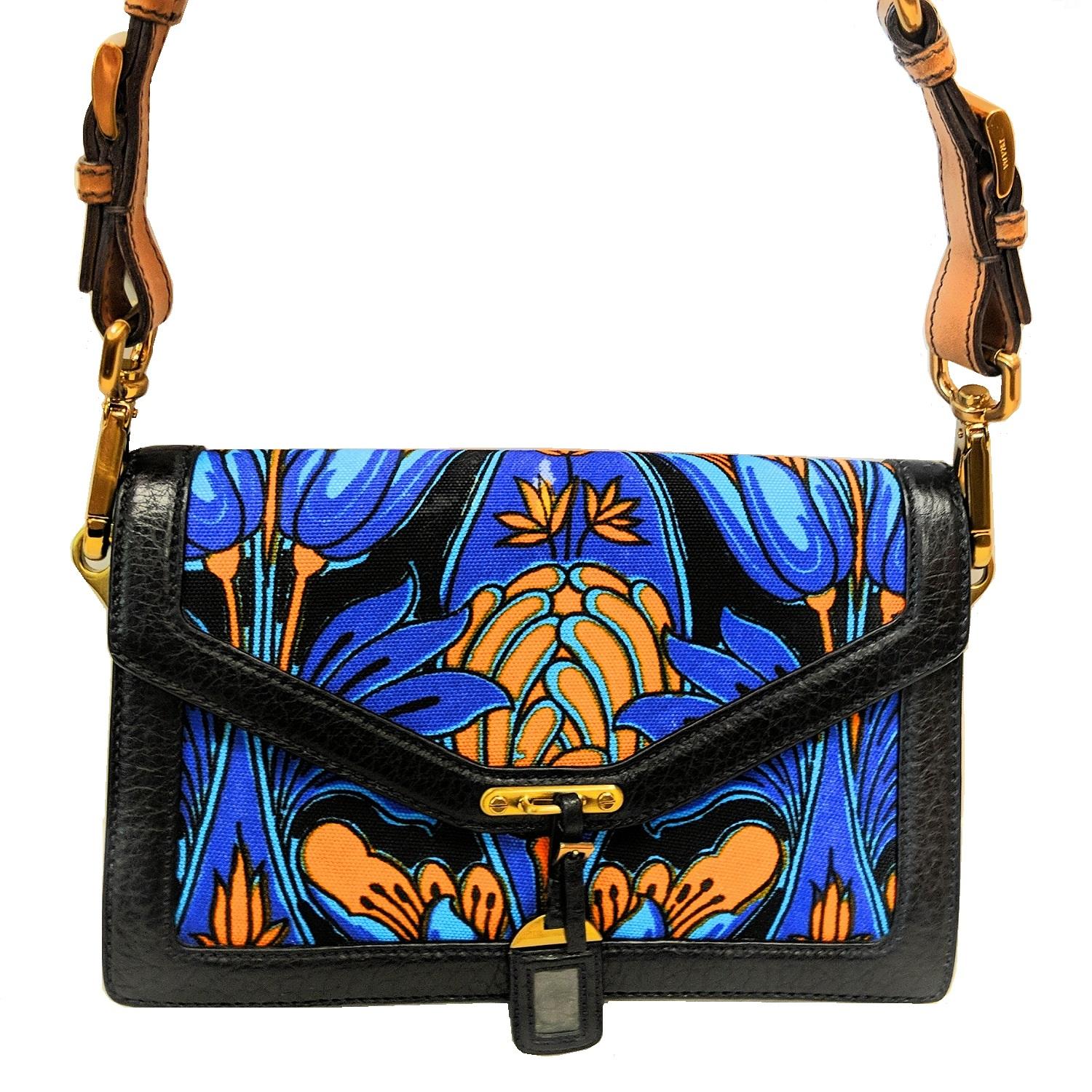 Prada multicolored cloth tropical motif print and black leather trimming flap bag with detachable light brown shoulder strap. Magnetic fastening with small black leather tag detail. 2 main layer: 1 layer with 2 slip compartments; 1 layer with 1 slip
