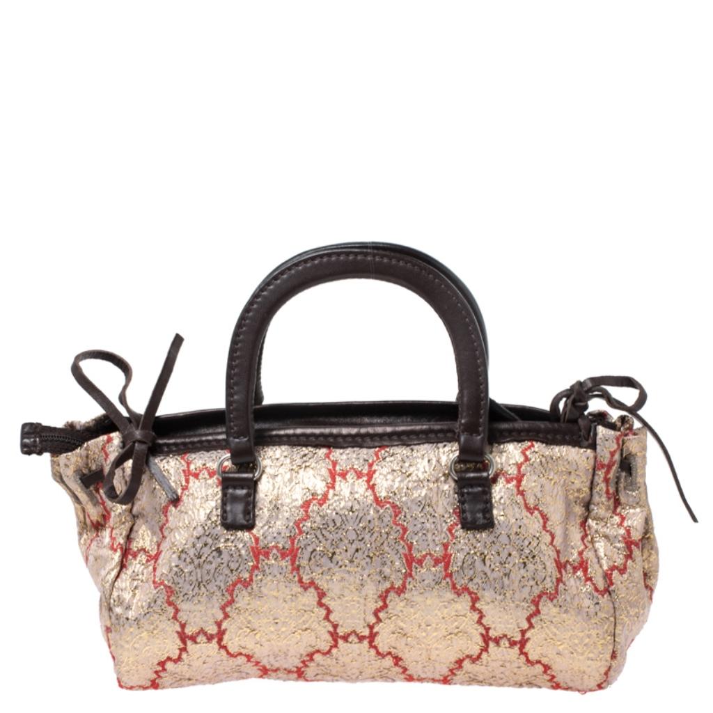 Keep it classy and elegant with this handbag from the house of Prada. Crafted in Italy, it is made of quality brocade fabric and leather. This satchel is classy and exudes sophistication. It is held by dual handles and comes with a top-zip closure