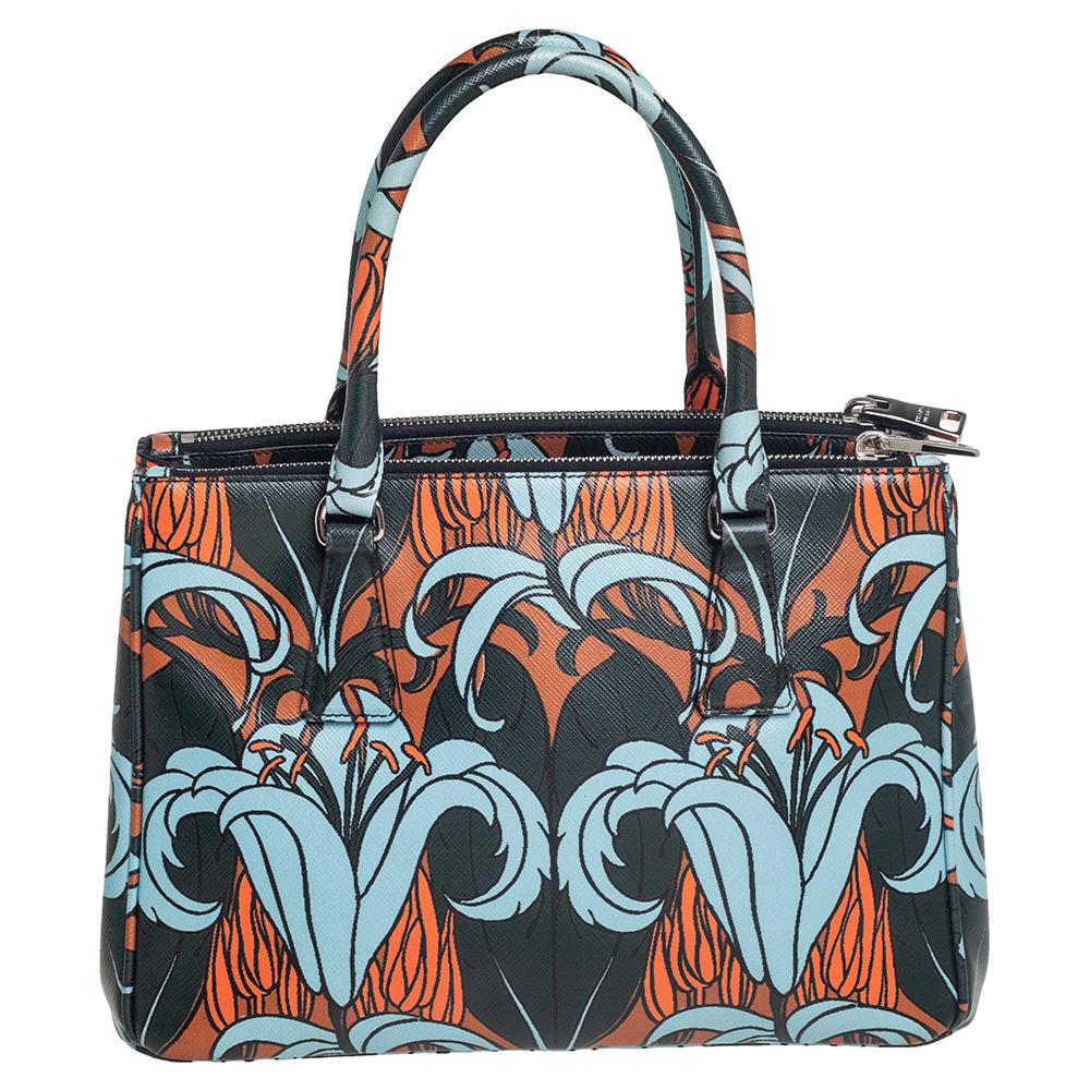 Die Galleria ist eine der kultigsten und beliebtesten Taschen aus dem Hause Prada und wird für ihre klassische Ausstrahlung und ihr funktionales Design geliebt. Diese mehrfarbige Schönheit ist aus mit Lilien bedrucktem Saffiano-Leder gefertigt und