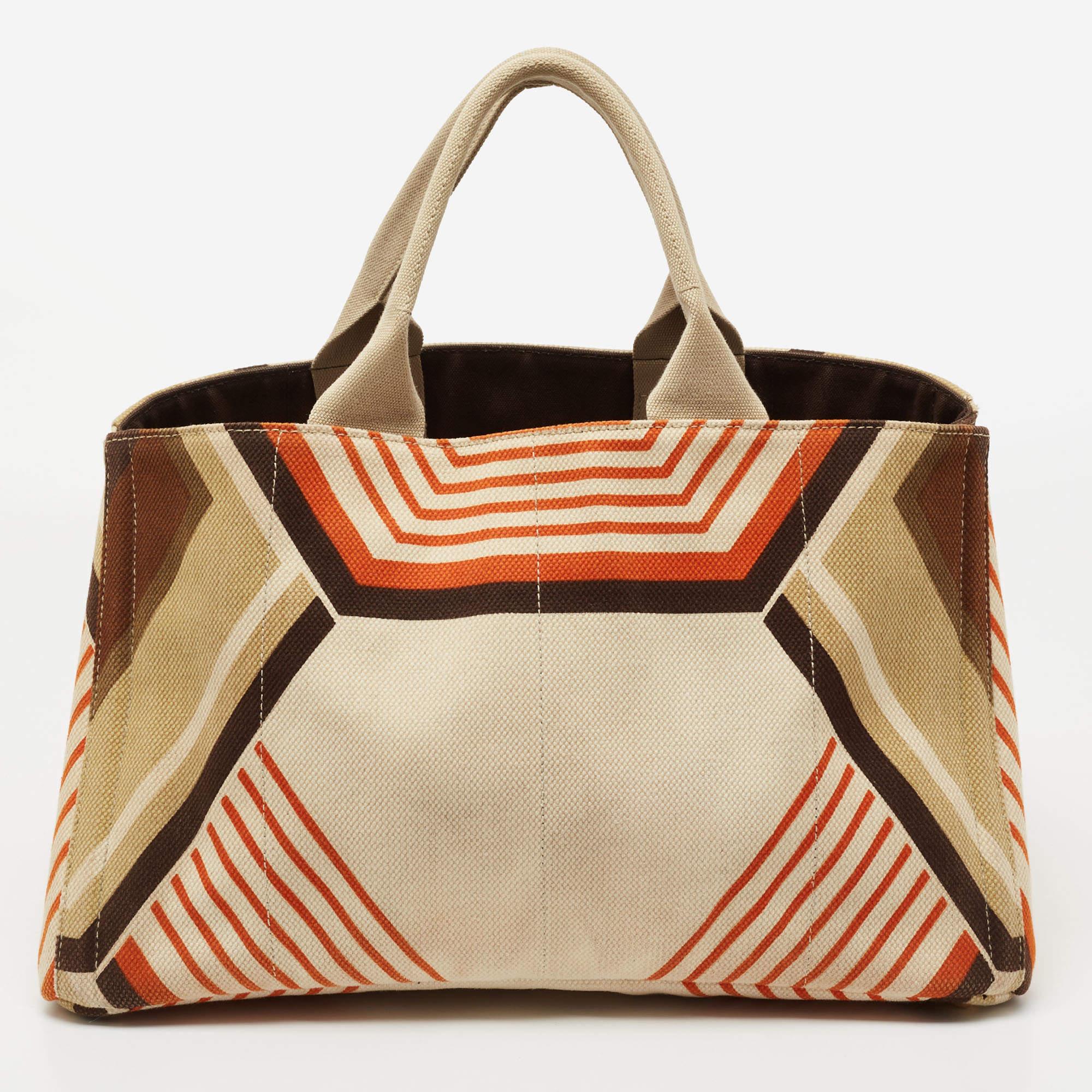 This fabulous Canapa tote by Prada is a bag ready to blend in with the busy lifestyle of the women of today. Meticulously crafted from printed canvas, it features a multicolored body and dual top handles for you to parade it. The structured bag