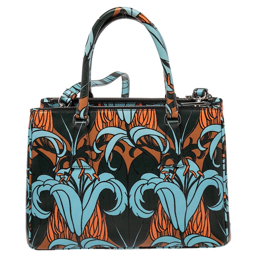 This Double Zip tote by Prada will be a loved addition to your closet. It has been crafted from printed Saffiano leather and styled with silver-tone hardware. It comes with two top handles, two zip compartments, and a perfectly-sized main