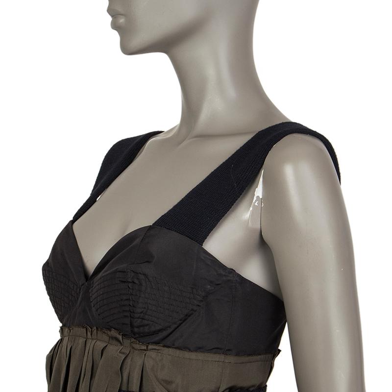 Prada dress in musk green, dark green, silk (56%) and polyester (44%) top. With an attached skirt in black silk (100%). With bustier-style padded cups, irregular pleats at the front and the back, deep slits on the sides. With dark blue straps and a