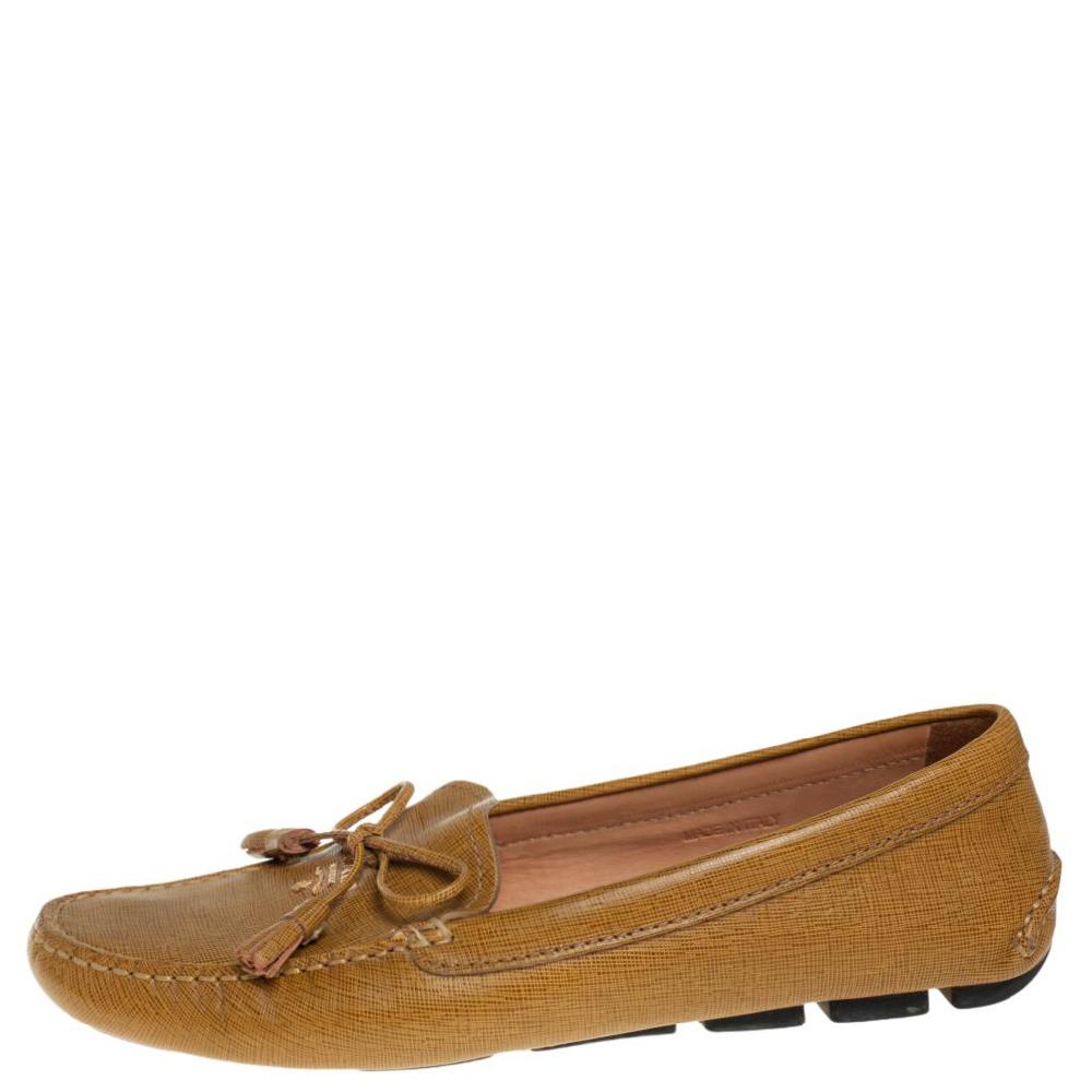 A seamless blend of comfort, class, and luxury, these Prada loafers are closet staples. Crafted from leather in a mustard yellow shade, they are detailed with tasseled bows on the uppers. They can be styled with multiple outfits.

Includes: Original