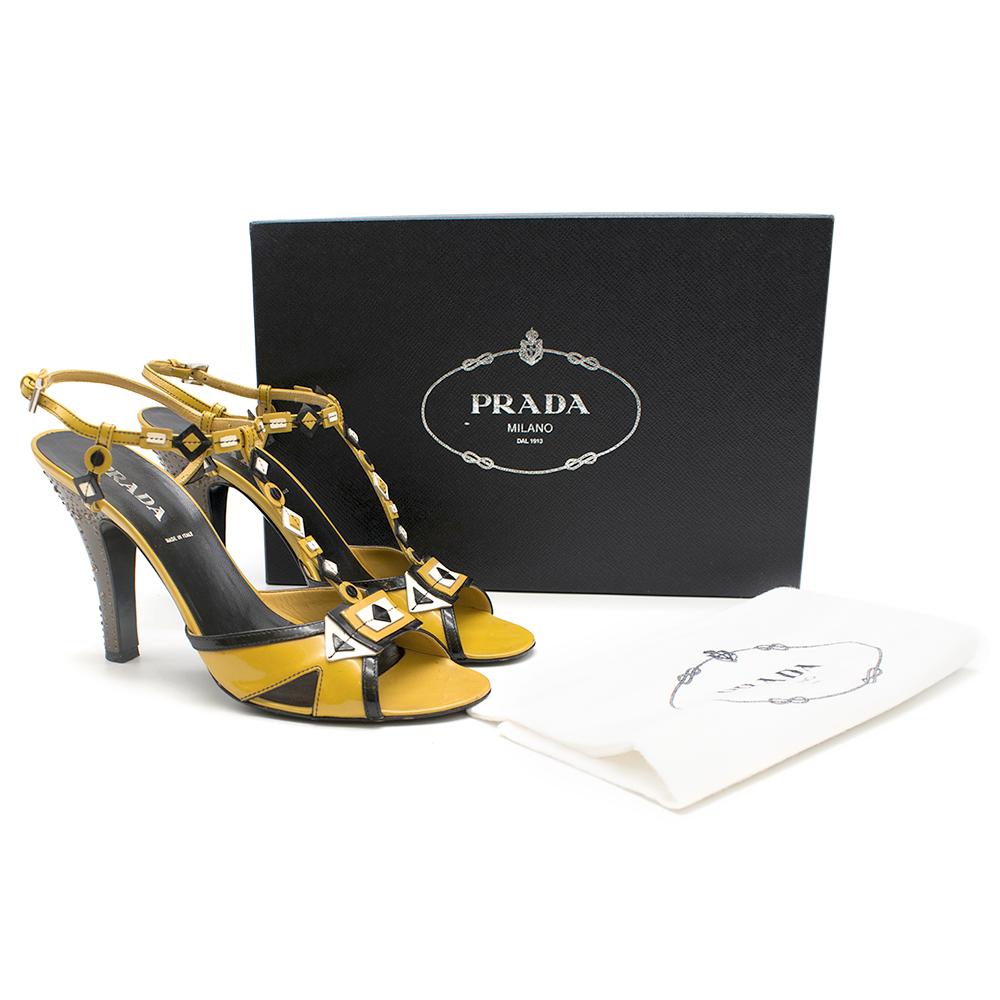Yellow patent leather heels from Prada with black and white details and a brown, crystal-embellished heel. 

- 10 cm Heel
- Box and dustbag included

Please note, these items are pre-owned and may show signs of being stored even when unworn and