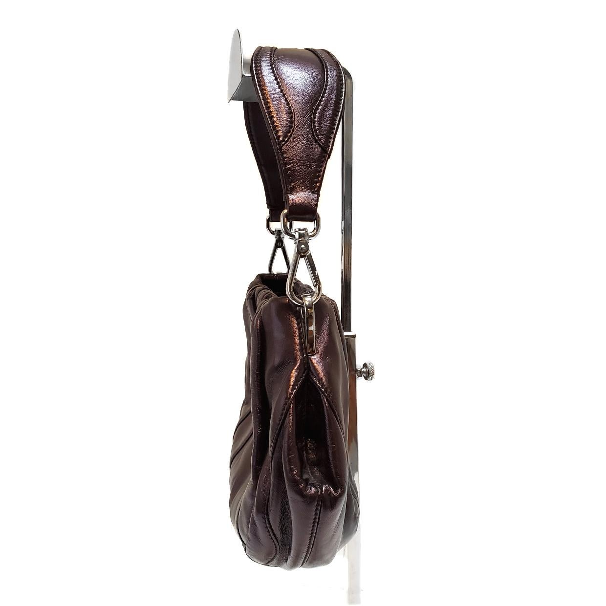 Brand - Prada
Collection - Nappa Waves
Estimated Retail - $1,495.00
Style - Hobo Bag
Material - Leather
Color - Metallic Wine
Closure - Snap
Hardware Material - Silvertone
Size - Small
Feature - Detachable Strap
Accent - Additional Crossbody