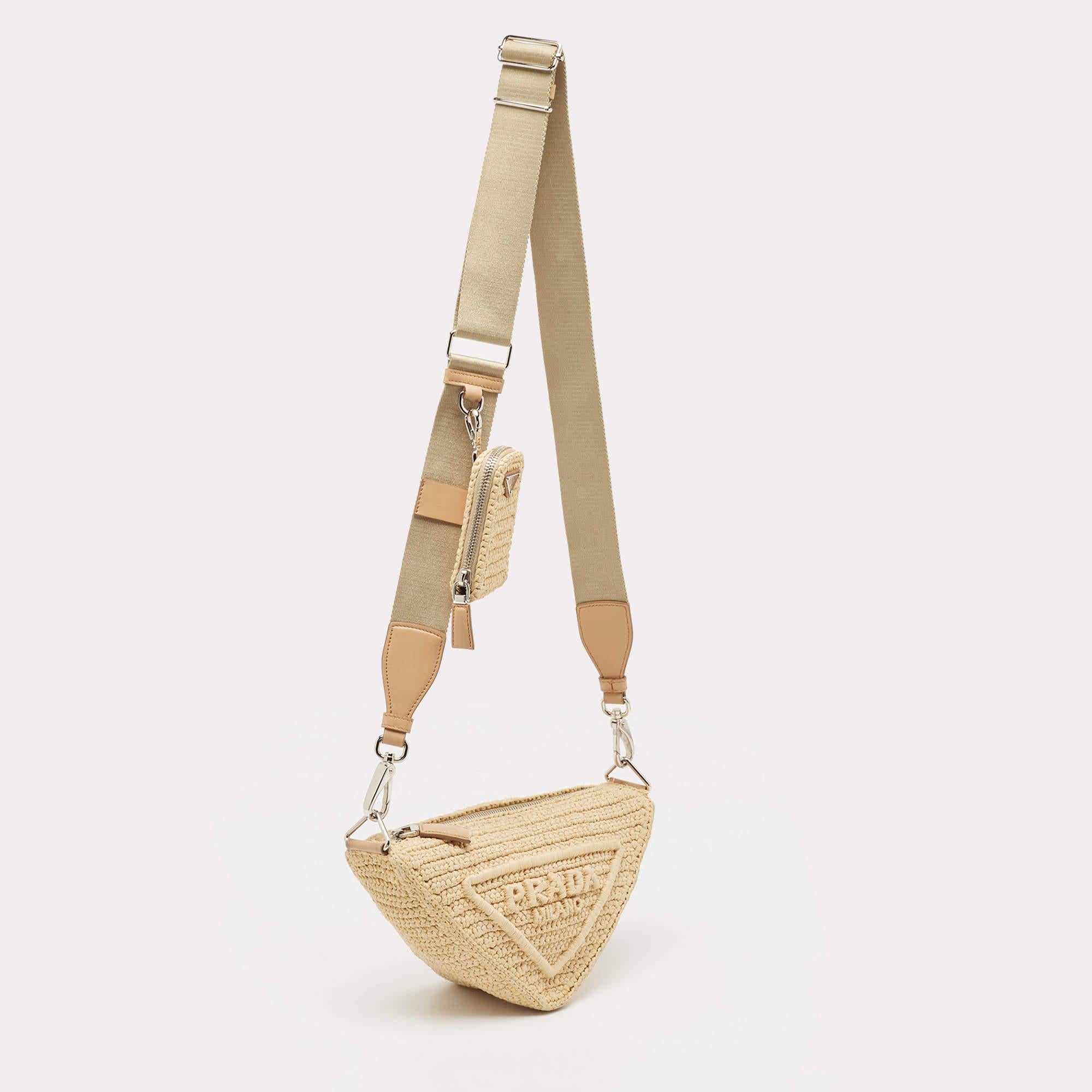 The Prada shoulder bag exudes effortless elegance with its intricate crochet design in earthy tones. Crafted with precision, its triangular silhouette adds a modern twist to a classic style. Perfect for summer outings or adding a touch of