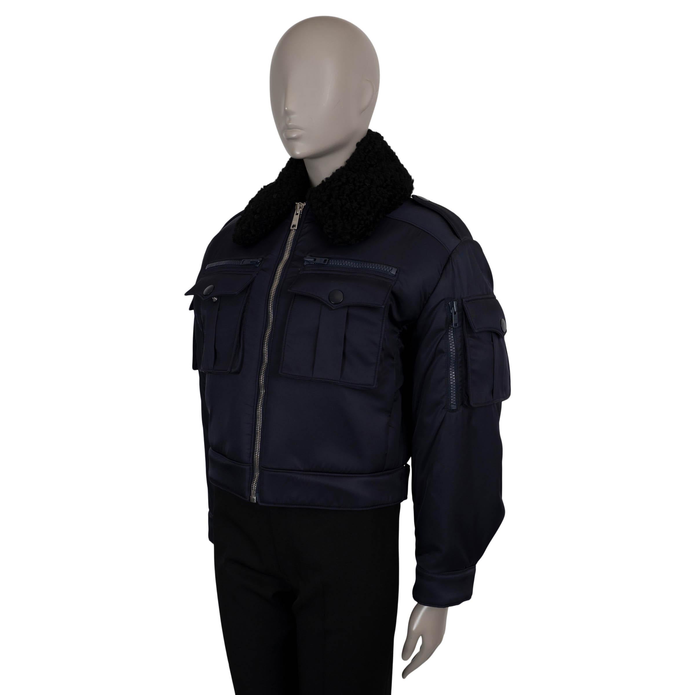 Cette veste bombardier 100 % authentique de Prada est réalisée en polyamide gabardine bleu marine (100 %), alliant précision militaire et détails luxueux. Il présente une silhouette boxy et cropped, ainsi qu'un col en shearling noir contrasté qui