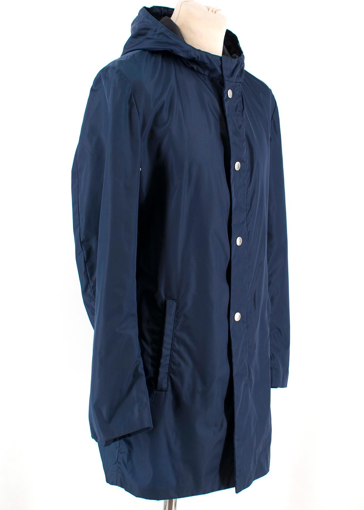 Prada Navy Blue Nylon Water-Proof Jacket 

- Engraved Logo Buttons 
- Front Zip and Snap Button Closure 
- Long Sleeved
- Attached Hood 
- Side Zip Pockets 
- Central Back Slit 

100% Nylon 

Made in Italy 

Measurements are taken with the item