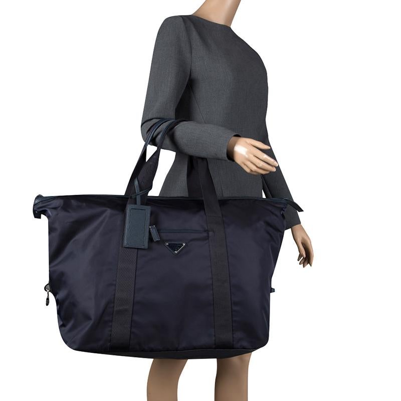 Designed to assist you on your travel sprees, this Prada Weekender bag comes crafted from nylon and styled with two top handles and the brand logo on the front. It has a spacious interior with a zip pocket and the bag is accompanied by a number