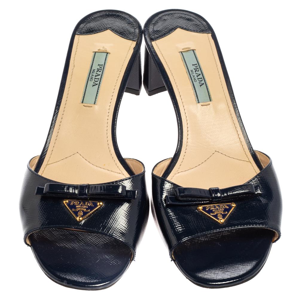 Designed especially for fashion queens like you, these Prada mules are absolutely gorgeous! They come flaunting a bow-adorned patent leather strap, comfortable insoles, and block heels measuring 4.5 cm. To look your best, wear the pair with culottes
