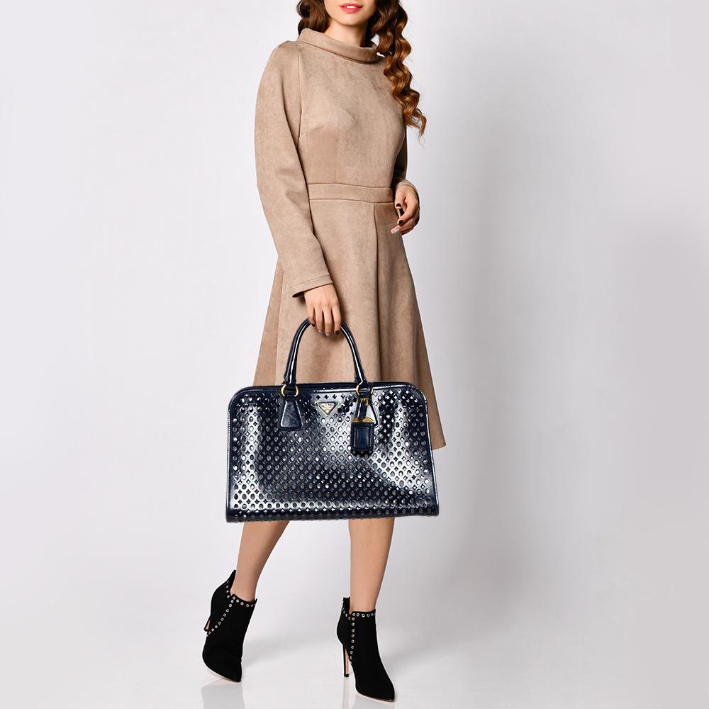 High on appeal and style, this tote is a Prada creation. It has been crafted from perforated patent leather and shaped to exude class and luxury. The bag comes with two handles, a spacious PVC & leather interior, and gold-tone hardware. Protective