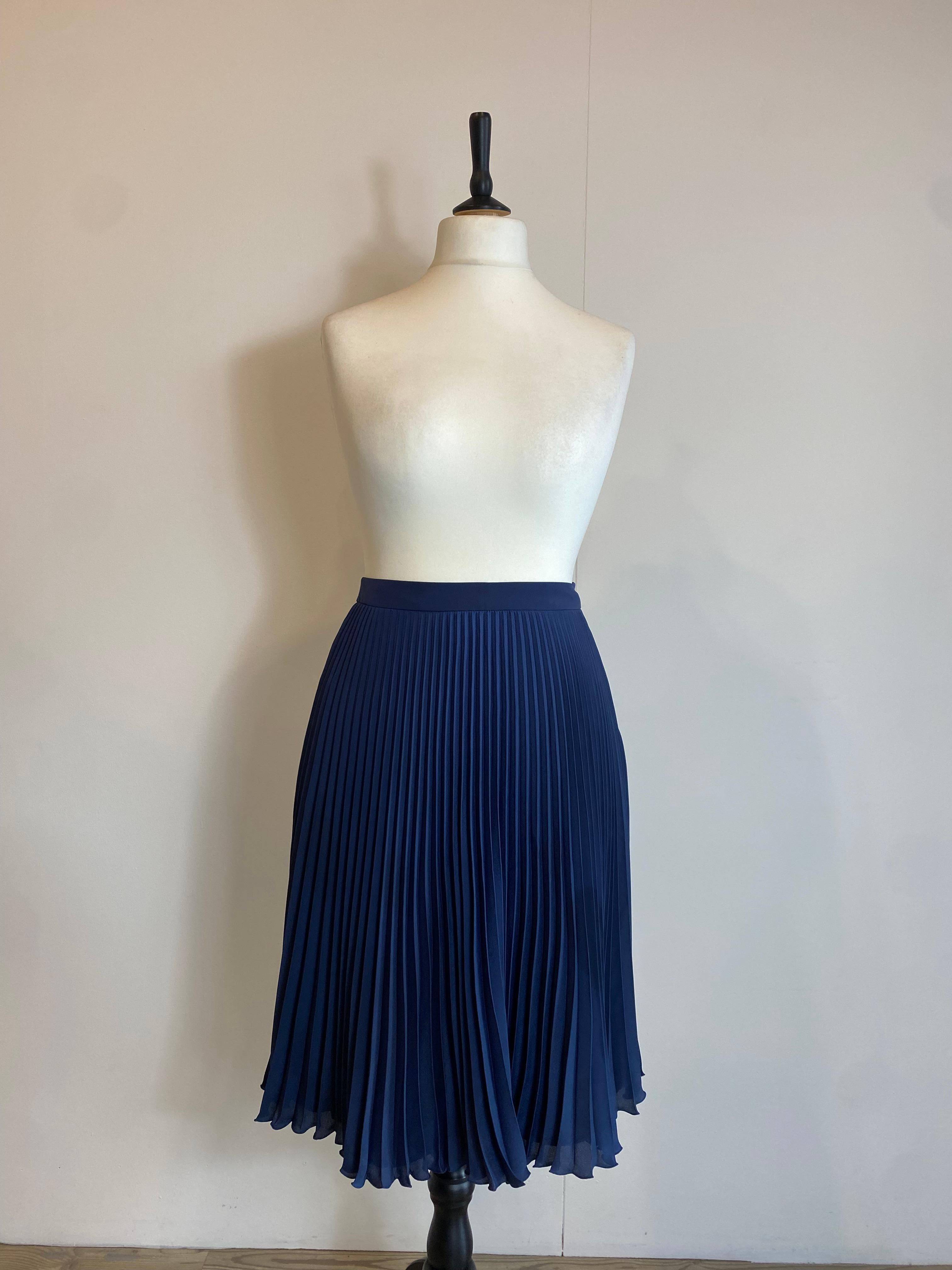 Prada skirt. 
Navy blue color, pleated. Composition label missing but we think it is silk. Lined. Side zipper closure. Italian size 40 but fits larger. Waist 36 cm Length 62 cm 
Excellent general condition, used very little