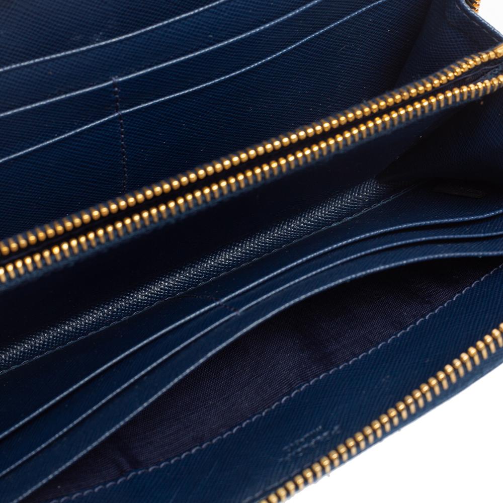 This wallet from the House of Prada is an essential accessory to own. It is made from navy-blue Saffiano leather on the exterior, with a gold-tone logo lettering placed on the front. The zip-around feature opens to a leather-nylon interior. Update