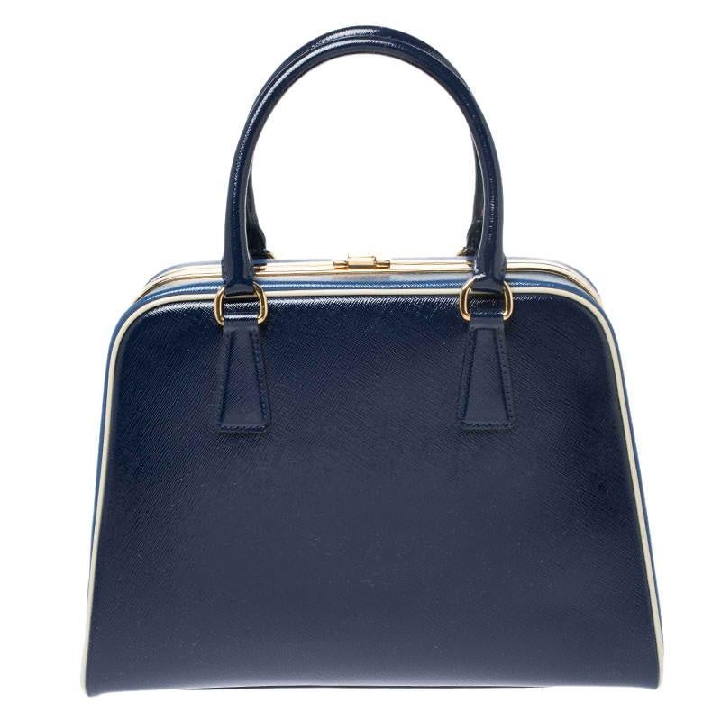 This stunning bag from Prada is crafted from leather and styled with gold-tone hardware. It features dual top handles and a metal lock which opens up to a perfectly sized leather interior ready to hold all your essentials. The accessory is complete