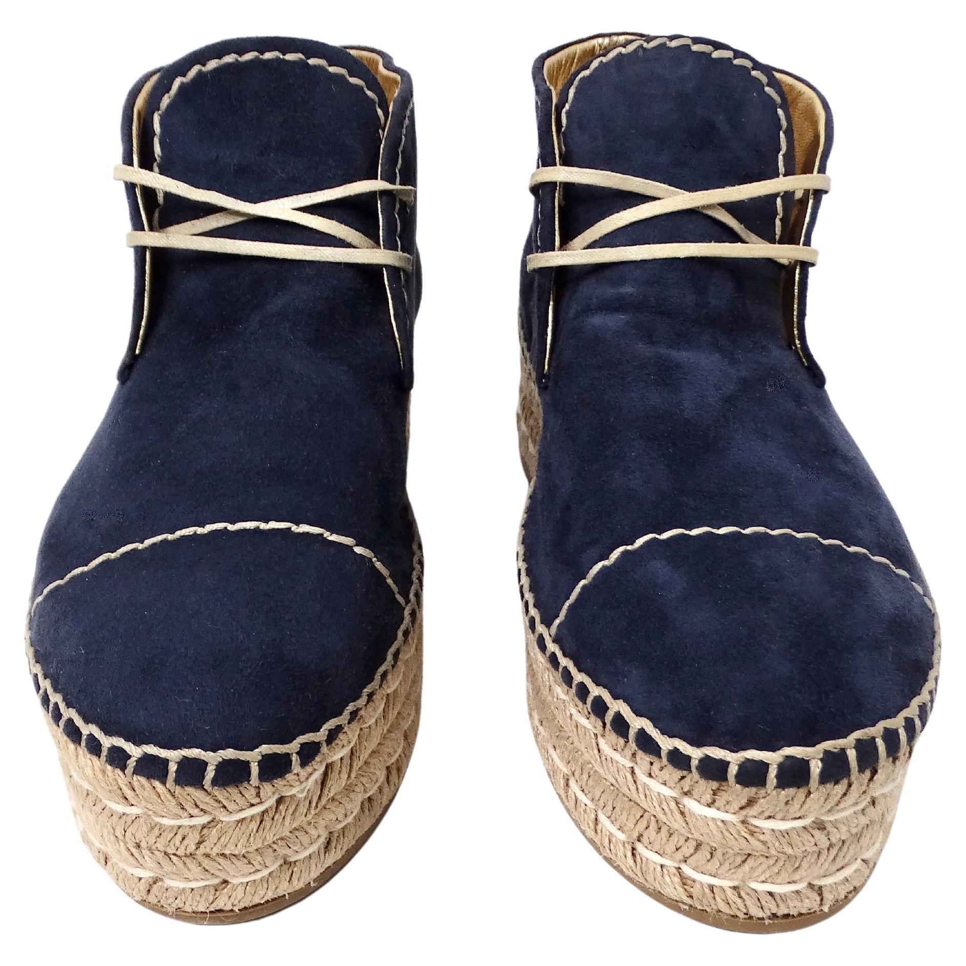 The Prada Navy Blue Suede Platform Espadrille Ankle Boots epitomize sophisticated casual luxury with a contemporary twist. Crafted from plush navy blue suede, these boots exude elegance while offering a relaxed, versatile vibe. The moccasin-like