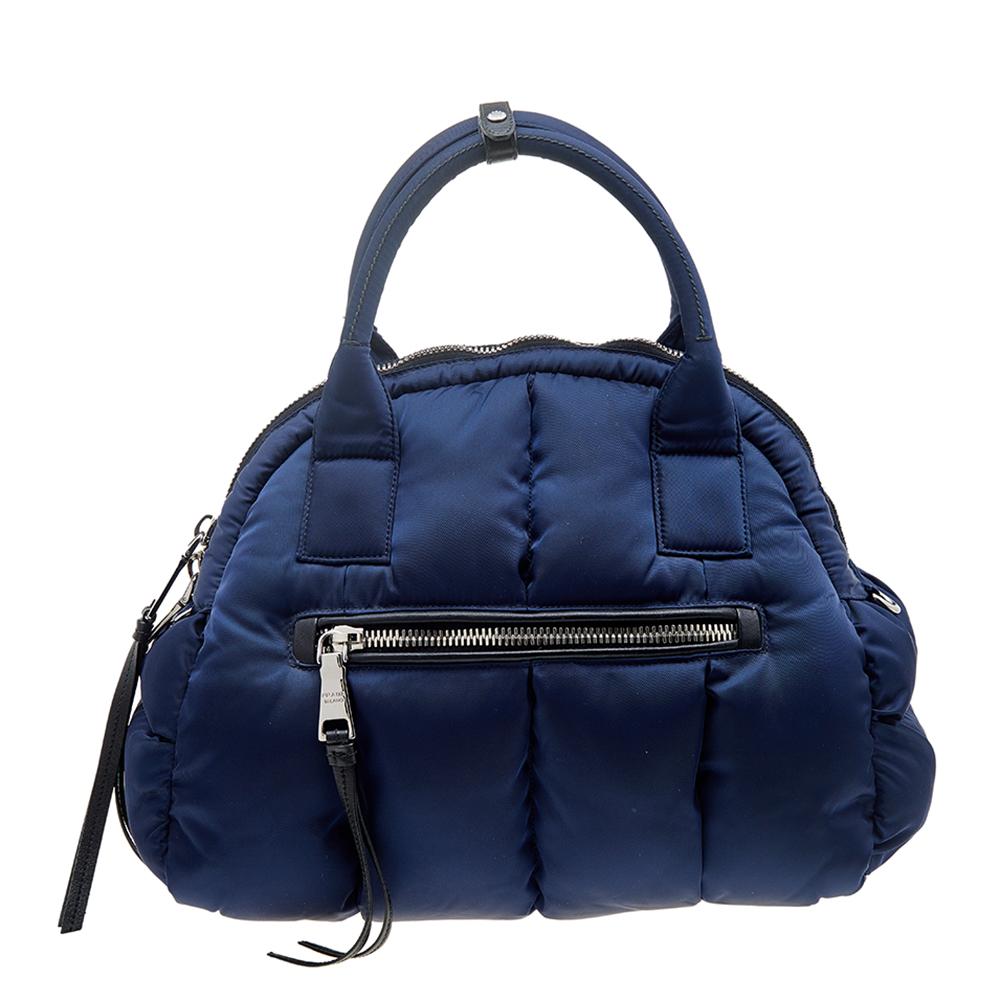 Let this Prada Bomber satchel accompany you on your next weekend getaway. With exterior zipper pockets on both sides and a spacious interior, it can perfectly house all your essentials. The triangular brand signature on the front makes this nylon
