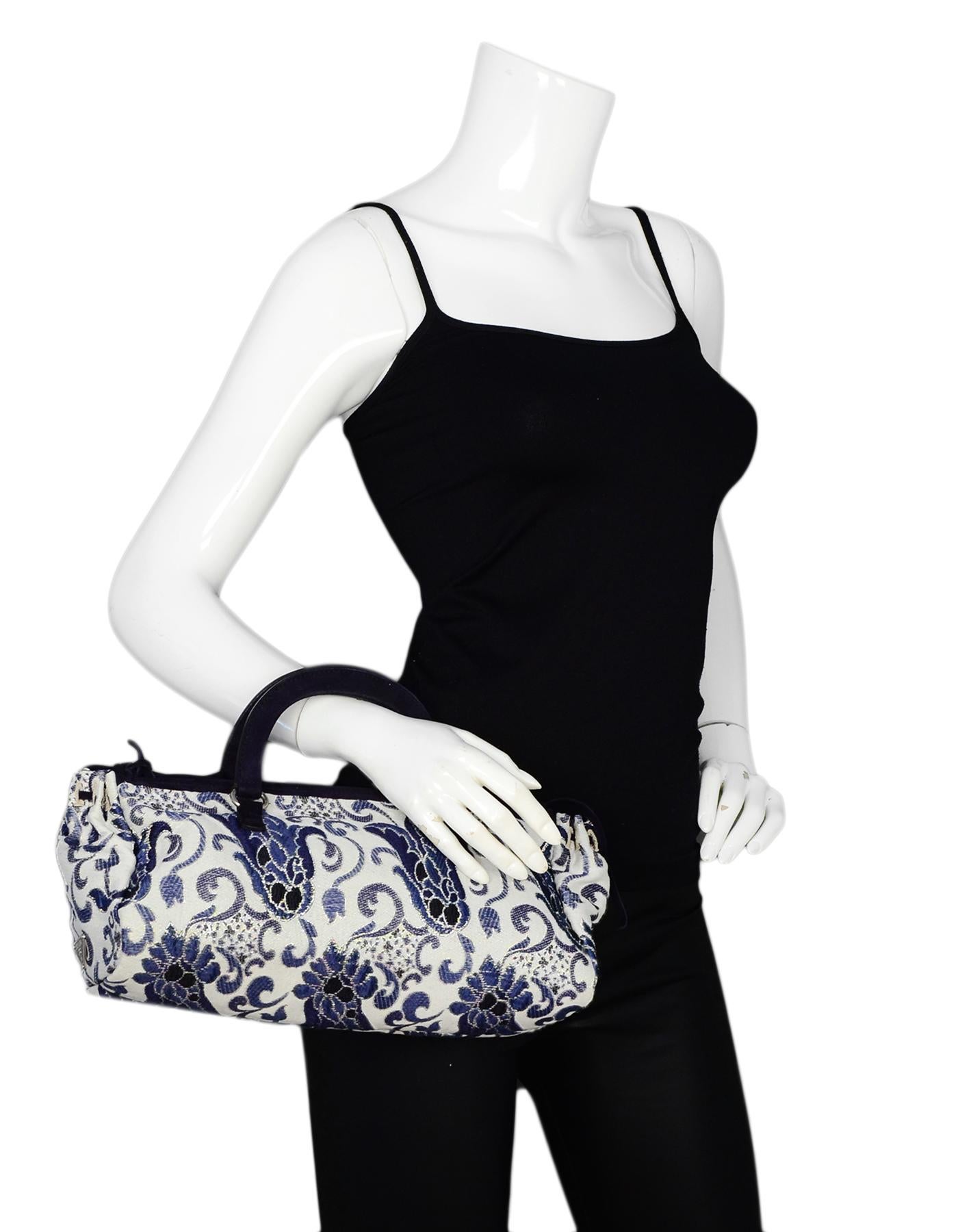 Prada Navy/White Brocade Handbag w/ Lurex

Made In: Italy
Year of Production: 2003
Color: Navy, white
Hardware: Silvertone hardwae
Materials: Brocade textile
Lining: Navy monogram textile
Closure/Opening: Top zip
Exterior Pockets: N/A
Interior