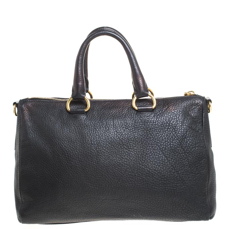 An essential wardrobe accessory, this Prada handbag is surely a must-have. Crafted from Vitello Daino leather, it comes in a classic shade of black. This satchel is styled with the brand logo on the front, dual handles, zip closure, fabric interior