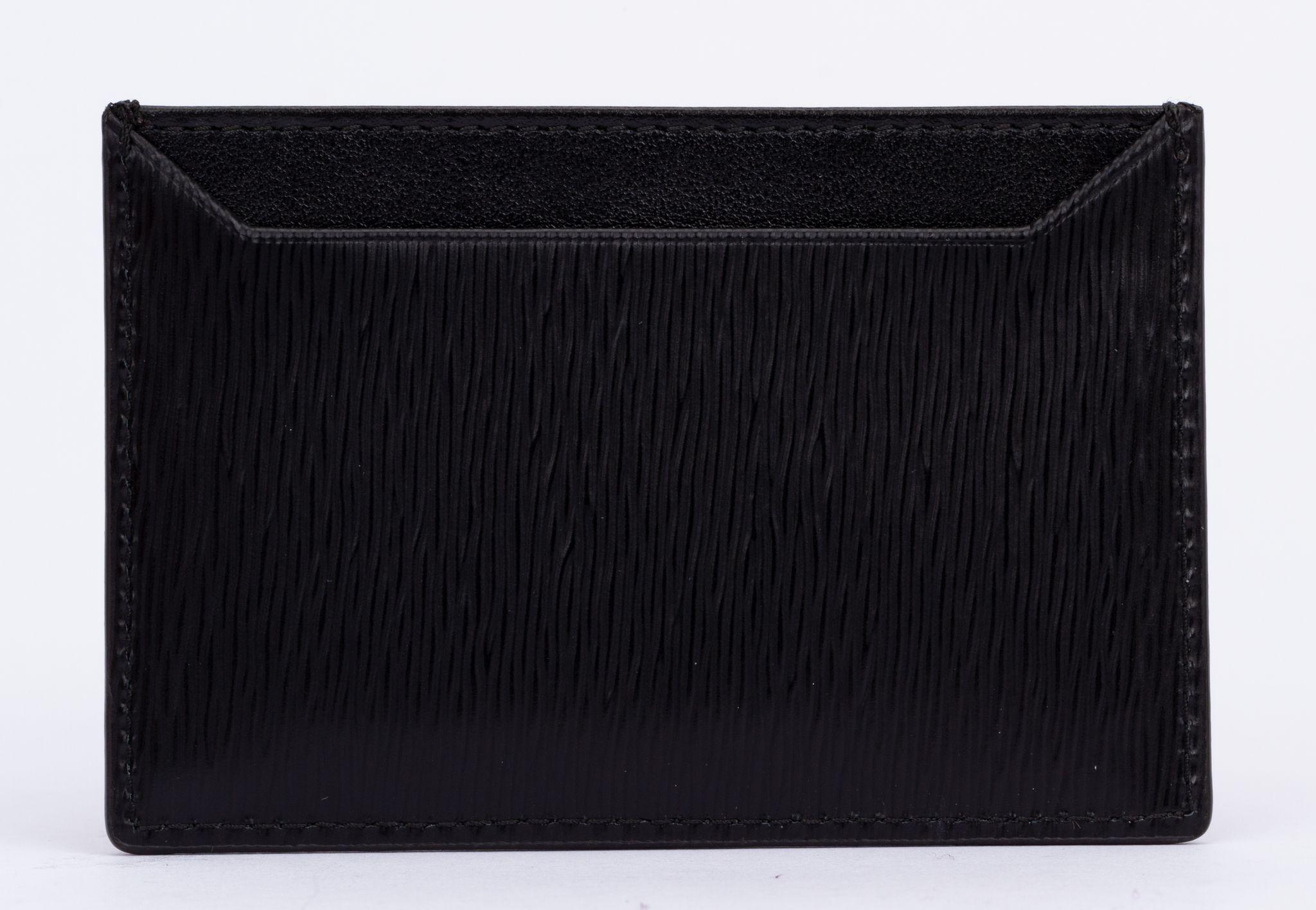 Prada Card Holder in Black. The Saffiano leather characterizes this sleek piece. The accessory with two card slots is decorated with a tonal enameled metal triangle logo. It come with the tag, booklets and original box.