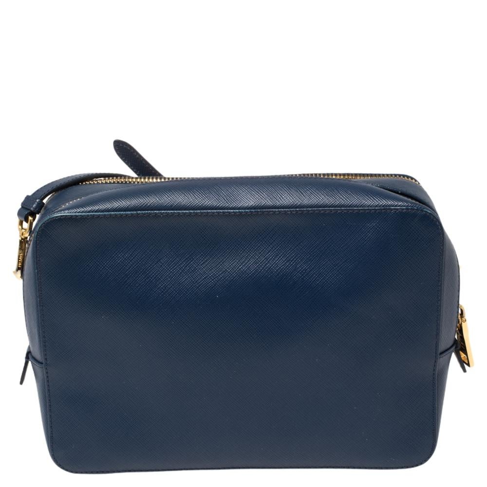 Diese strapazierfähige Kamera-Crossbody-Tasche von Prada ist ein wertvoller Kauf. Diese bequeme und leicht zu tragende Lederkreation ist in Marineblau gehalten und mit dem Markenlogo auf der Vorderseite versehen. Sie verfügt über einen verstellbaren