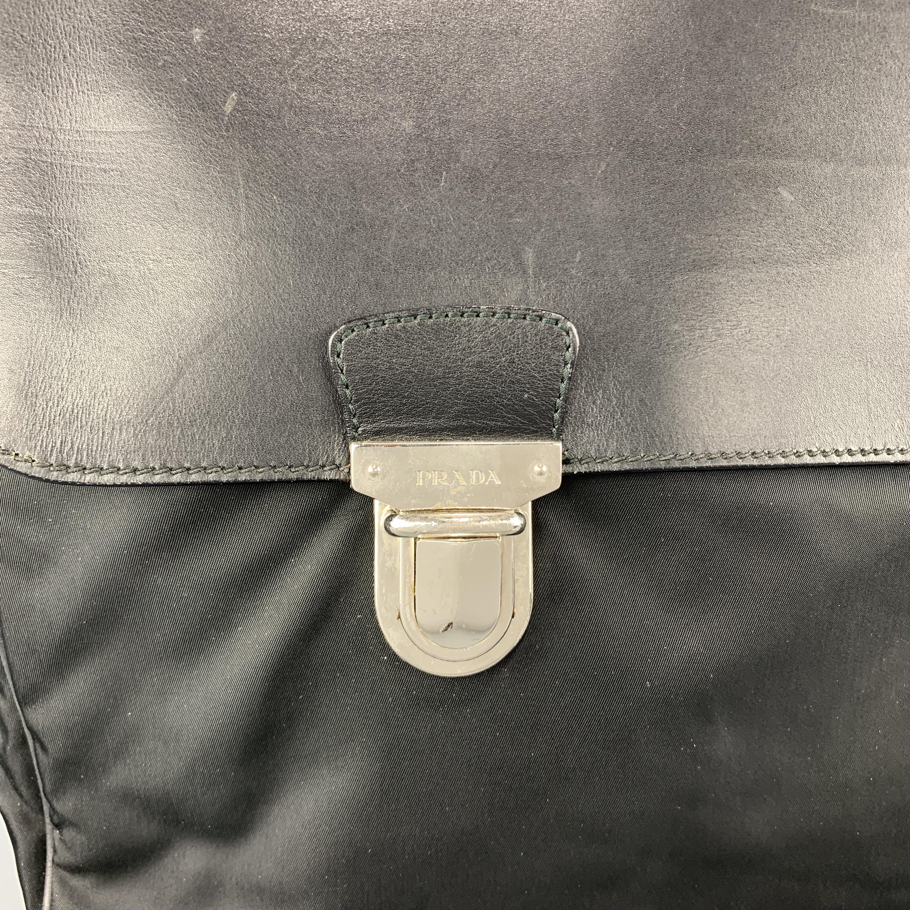 Vintage PRADA briefcase comes in nylon twill with two zip compartments, leather piping, and leather flap with double silver tone engraved snap closures and top handle. Wear throughout. As-is. Made in Italy.

Good Pre-Owned