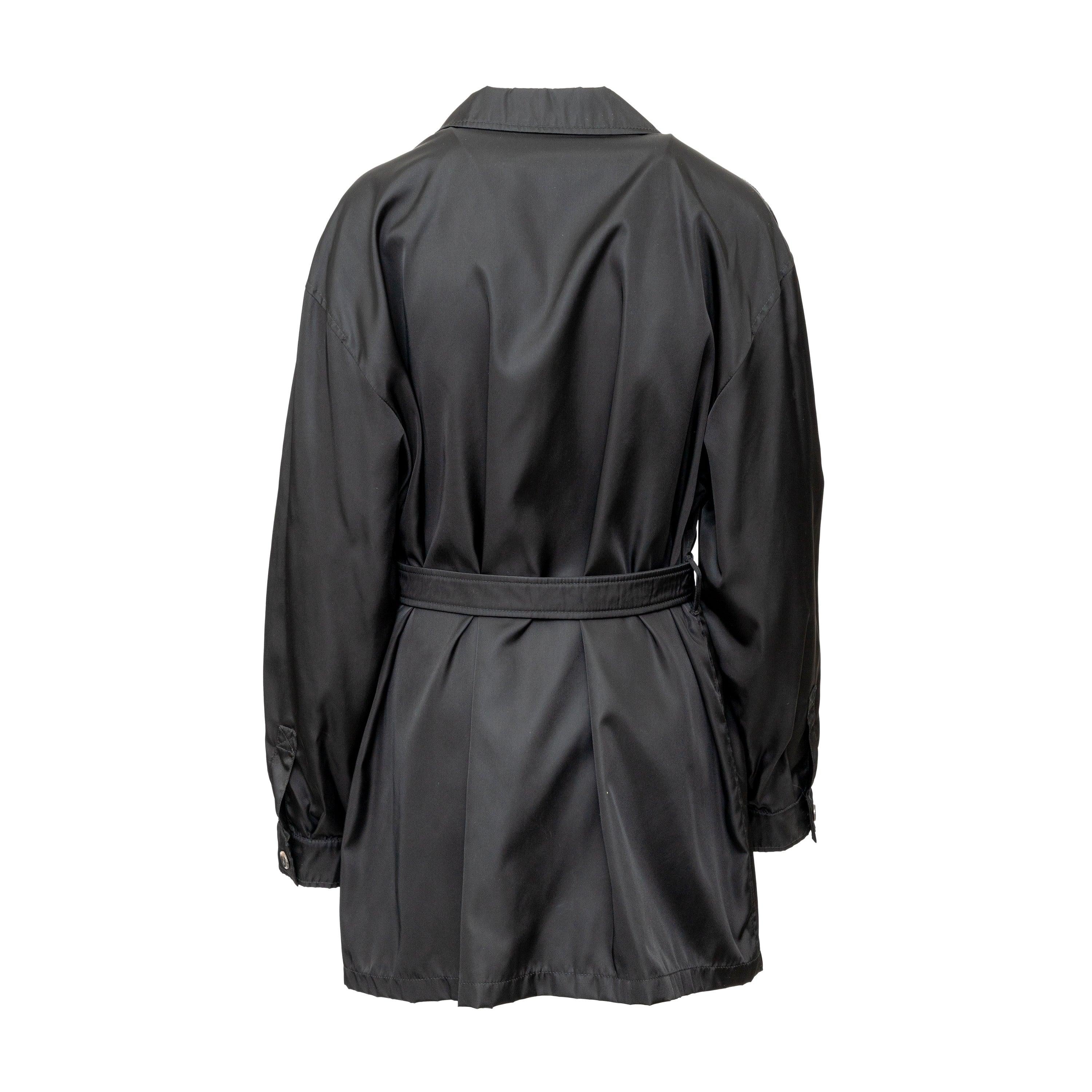 Prada trench coat in Re-Nylon fabric, double-breasted with waist belt and lapel collar. Stylish and functional, perfect for rainy days. A classic wardrobe addition. 
 Measurement: Shoulder:52;Sleeve:58;Bust:60;Length:82 
 Material: 100% Nylon