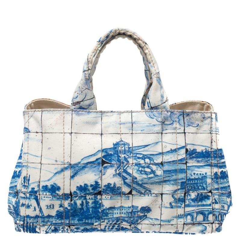 One of the most iconic designs from the house of Prada, this canvas Canapa tote bag is great to wear through the day or at your vacations whilst never compromising on style. Covered in prints of blue, this off-white bag features two handles, a
