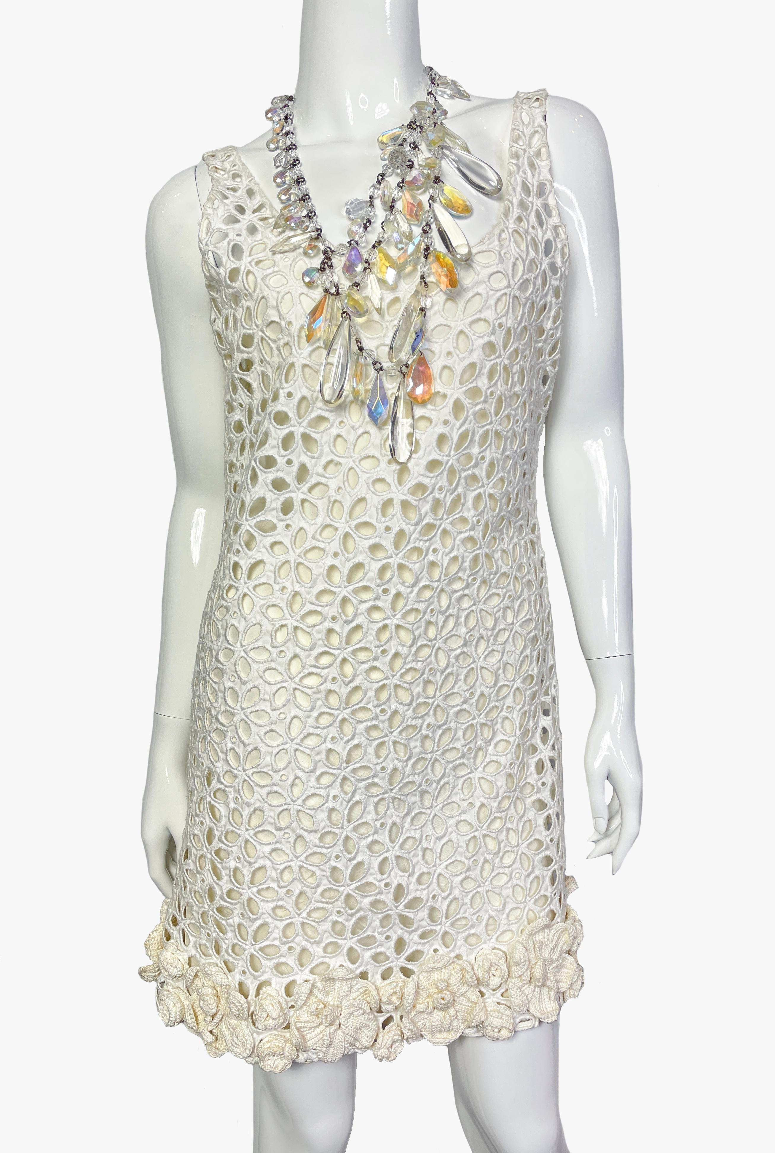 Rare robe en crochet blanc cassé à motifs floraux de Prada. Elle se compose de deux couches : la couche inférieure est en soie fine, la couche supérieure est à motifs floraux décorés au crochet le long de l'ourlet.
Décoré d'un collier multibrins en