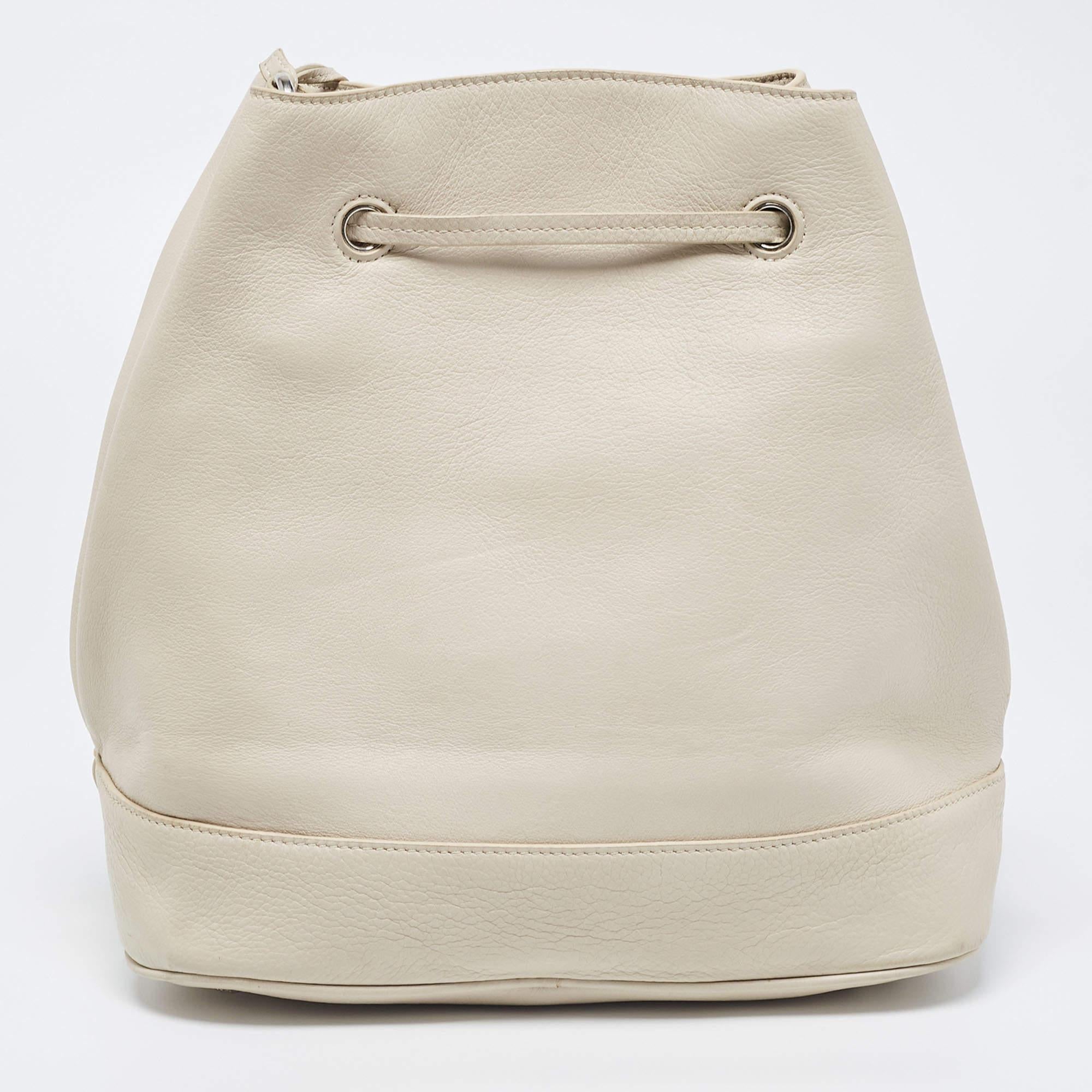 Feel confident and beautiful every time you carry this bucket bag from Prada. Crafted from off-white leather, this bag offers utmost practicality. It features a shoulder strap and a drawstring closure that secures a well-sized interior.


Includes: