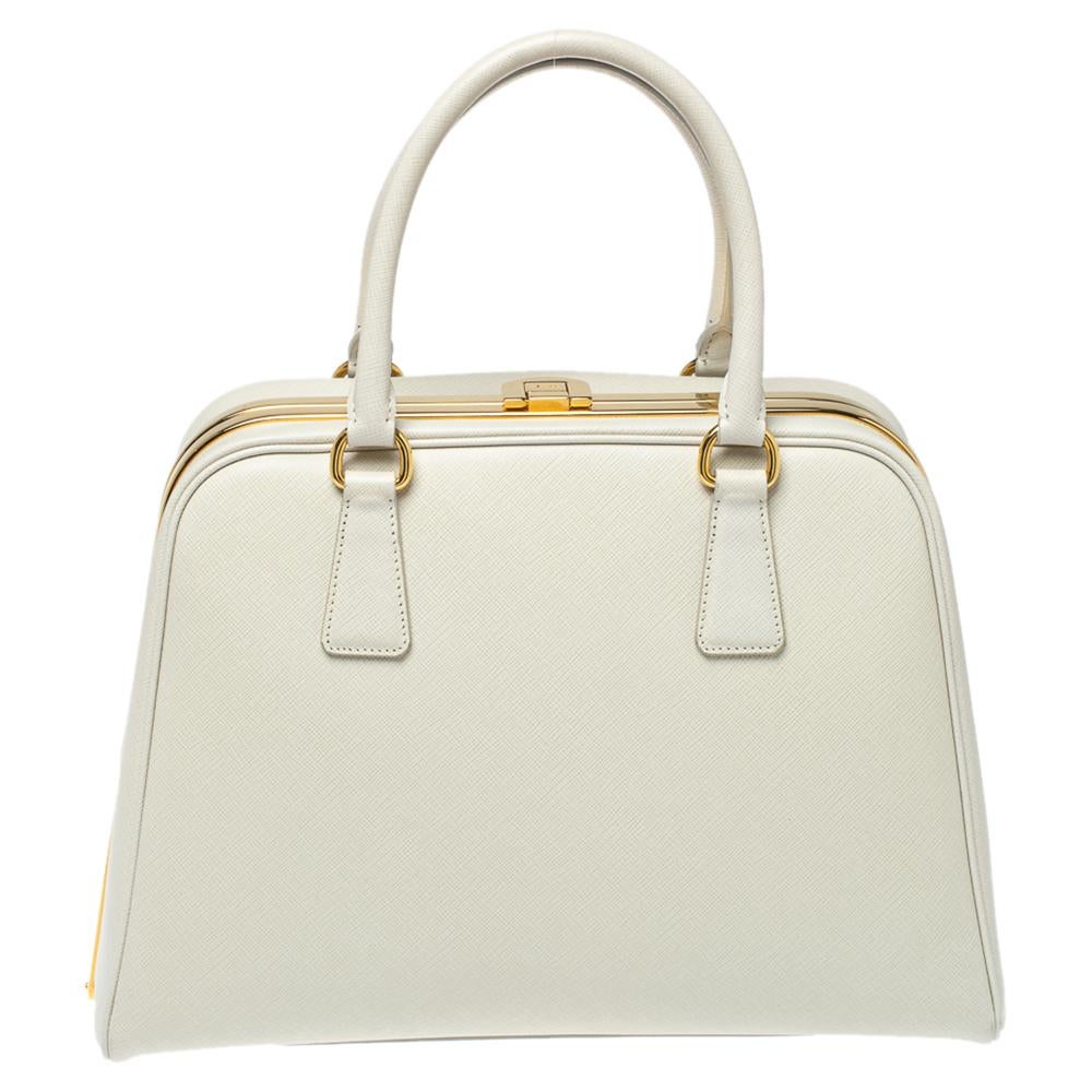 Giving handbags an elegant update, this Pyramid Frame bag by Prada will be a valuable addition to your closet. It has been crafted from leather and styled in a structured silhouette with a framed top. It comes with dual top handles, protective metal