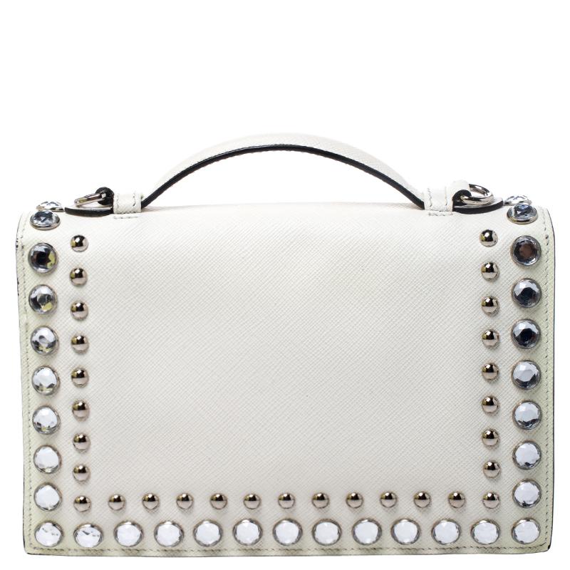 This Prada bag is an example of the brand's fine designs blended finely with the latest trends in fashion. Crafted from Saffiano leather, the bag is enhanced with studs. It features a top handle, a shoulder strap and a well-sized leather-lined