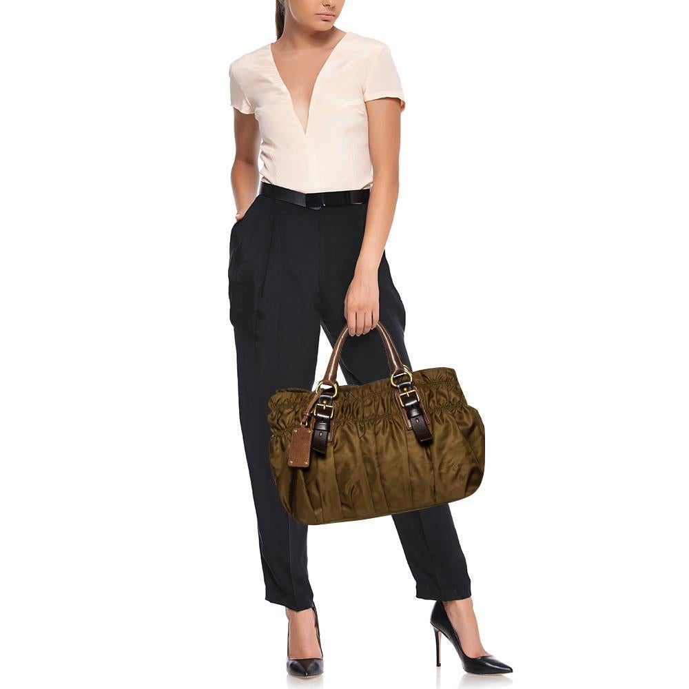 Prada brings you this lovely gathered tote that has been crafted from nylon and leather in olive green. It has a well-sized fabric interior and the bag is complete with two top handles. Stylish and ideal for daily use, this bag is a worthy