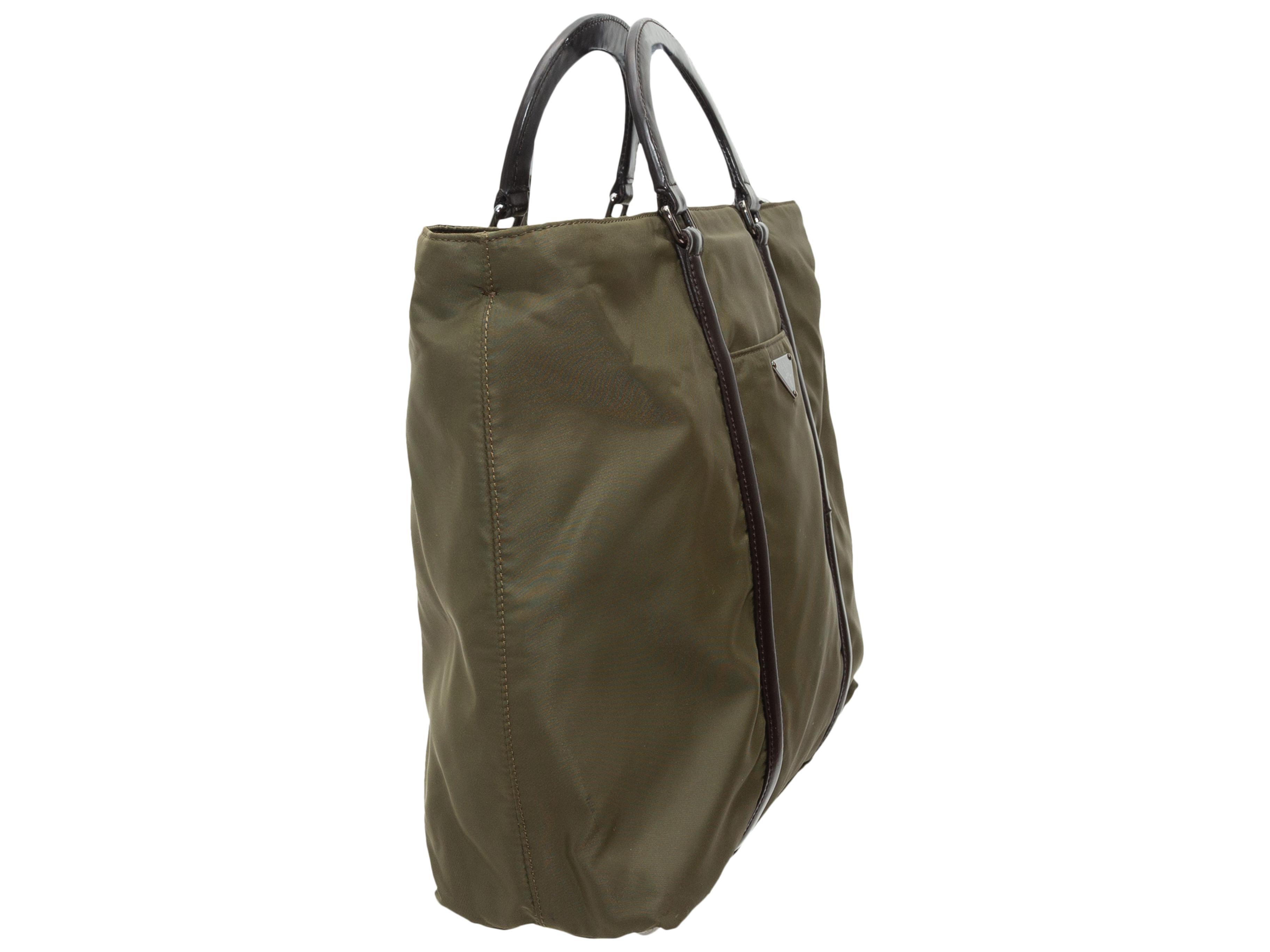 Product details: Vintage olive green nylon handbag by Prada. Dark brown leather trim throughout. Silver-tone hardware. Slit pocket at exterior front and exterior back. Dual top handles. Detachable shoulder strap. 14.5