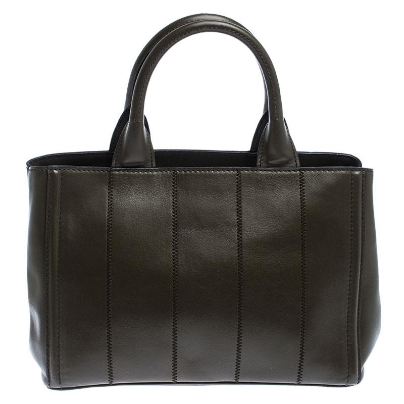 High in appeal and style, this tote is a Prada creation. It has been crafted from leather in Italy and shaped to exude class and luxury. The bag comes with two handles, a spacious nylon interior, and the brand label on the front. This tote is ideal