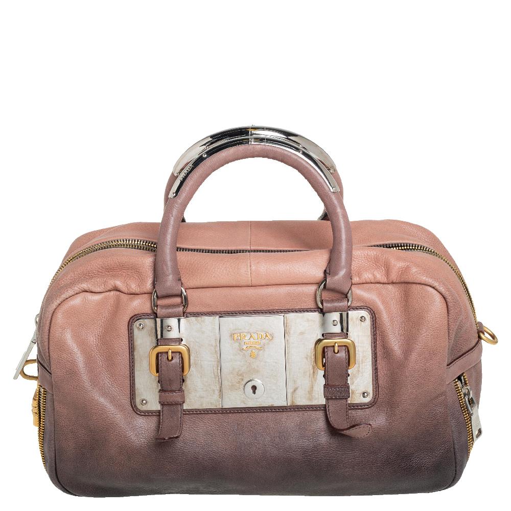 Prada’s Bauletto bag delivers a refined style through leather and a mix of gold-tone and silver-tone hardware. It comes with dual handles for your convenience and an ombre brown exterior. This stylish bag is roomy enough to hold all your daily